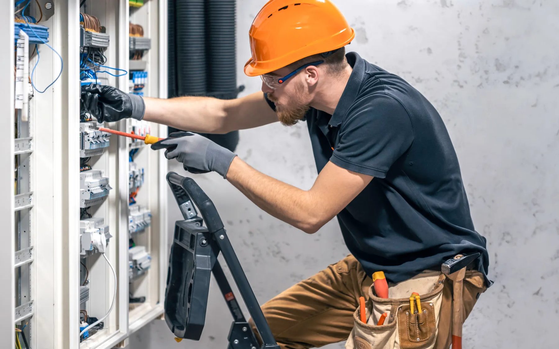 Electrician working inside an electrical panel
