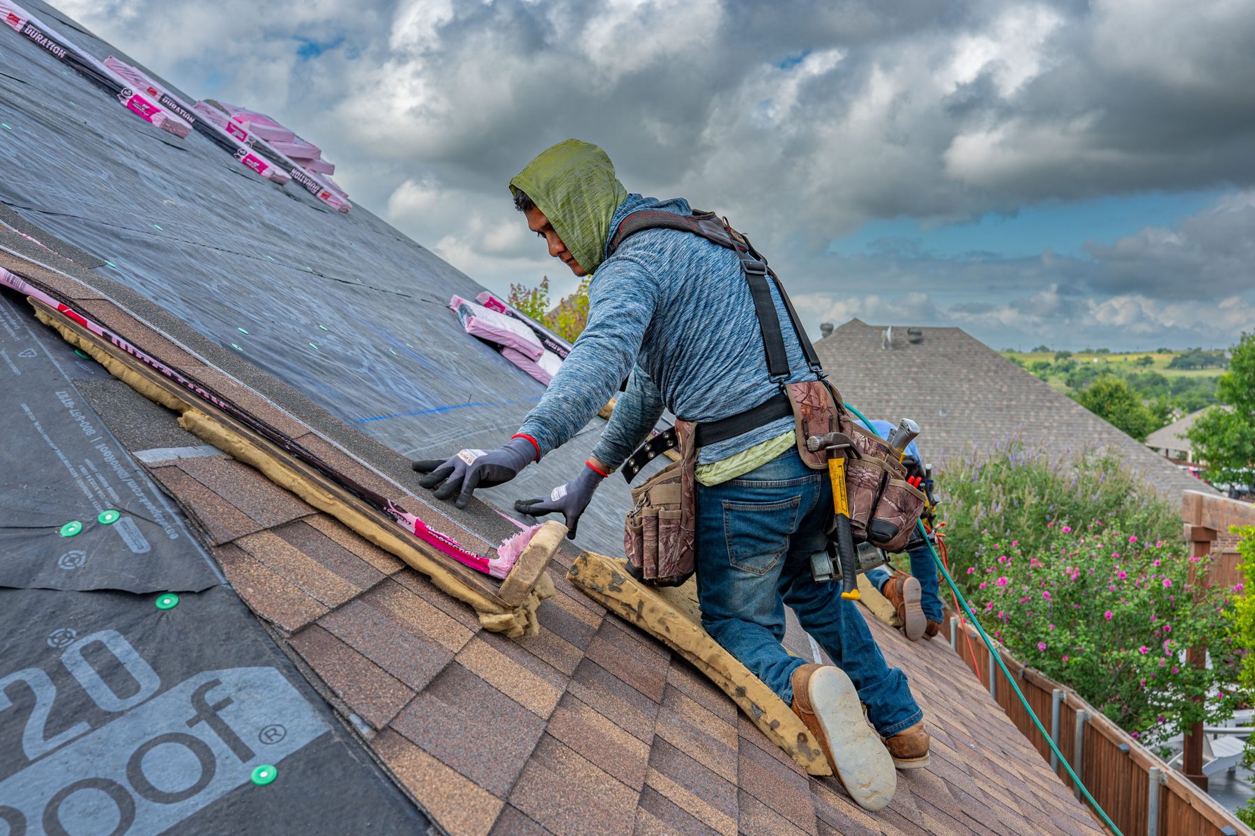 Roofer installing new shingles on a house